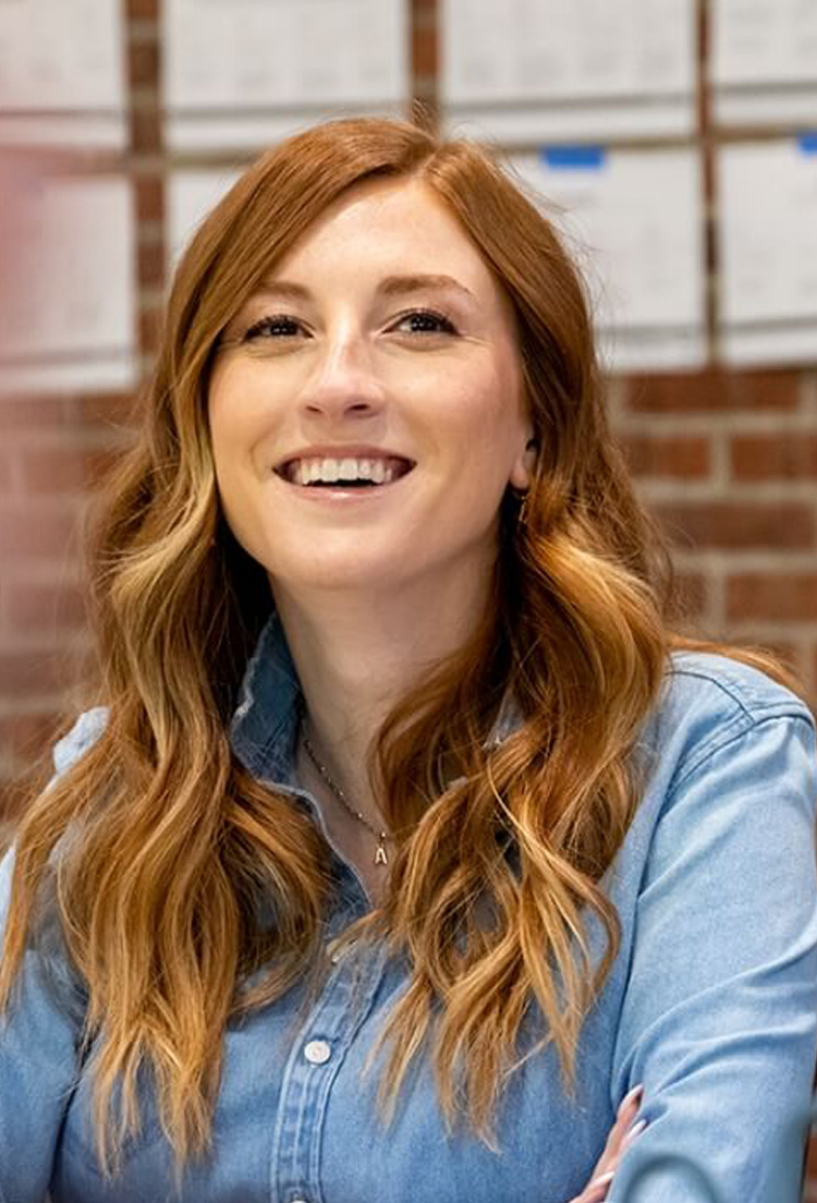 Over-the-shoulder view of a woman sitting at a table and smiling